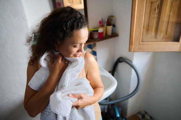 istock Woman Drying Herself with White Towels in a Bright Bathroom 2196170269