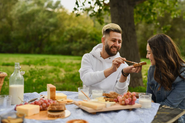 istock Caring Boyfriend Pampering Girlfriend Feeding Her Sandwich on Romantic Picnic Date 2196172011