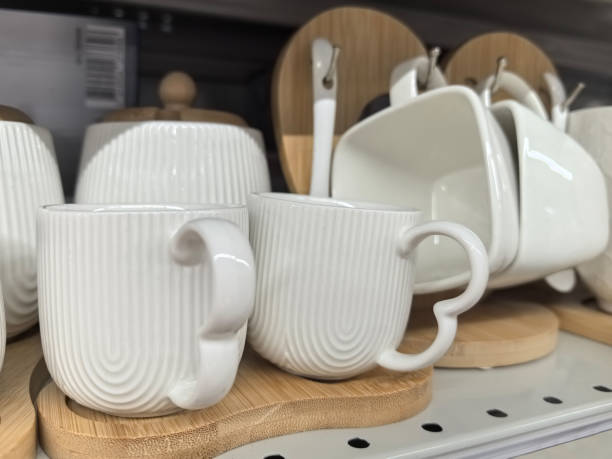 istock Elegant white coffee mugs arranged on a shelf with stylish accessories 2196175457