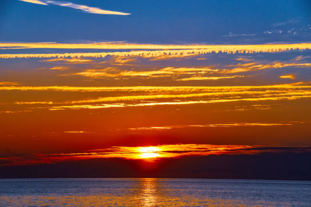 Chesapeake Bay in southern Maryland, colorful sunrise photograph with sun reflections in water.