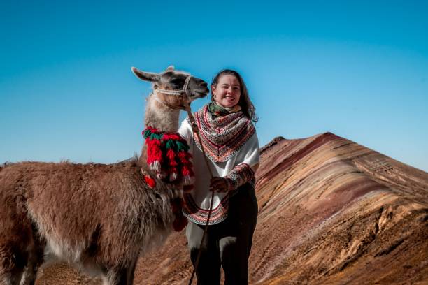 istock Young woman with llama at Rainbow Mountain, Peru. 2196179262
