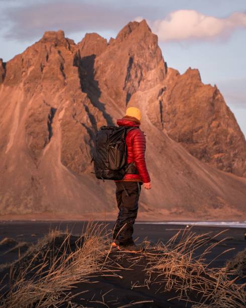 istock Hiker on black sand with mountain backdrop. 2196179305