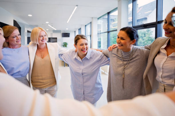 istock Businesswomen standing in the circle and hugging 2196179311