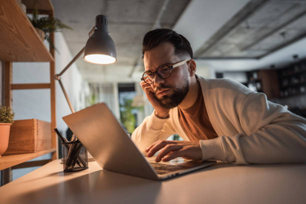 istock Young man working on his laptop at home 2196184007