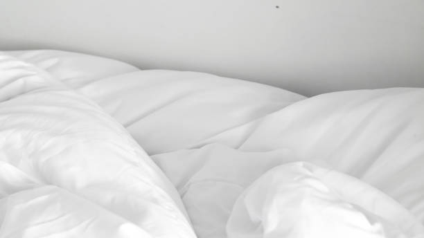 istock Soft and fluffy white linens on an unmade bed, highlighting minimalist design 2196189166