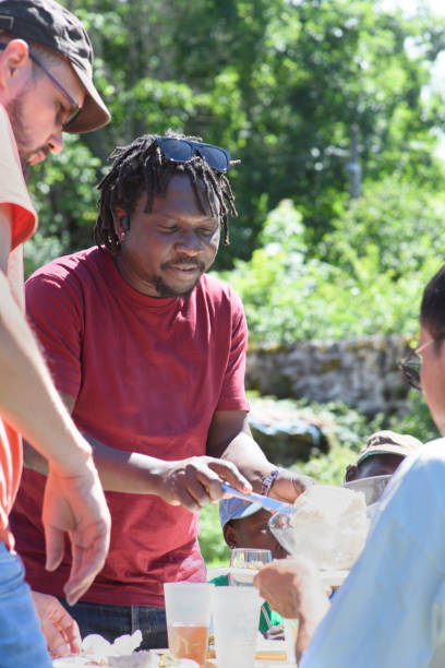 istock During a picnic an african distributes cottage cheese to his friends 2196192341