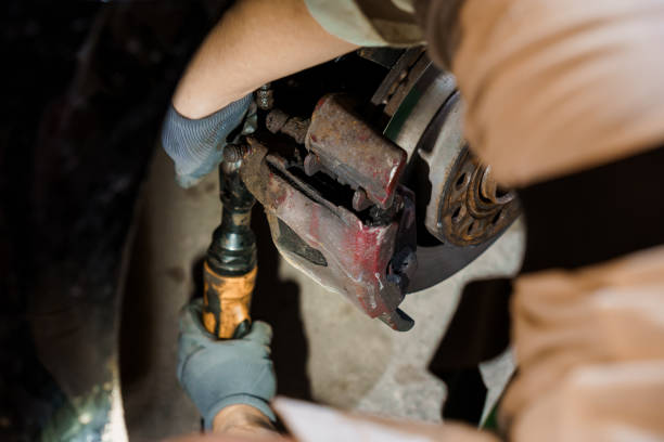 Skilled Mechanic Performing Brake Caliper Replacement in a Dimly Lit Garage