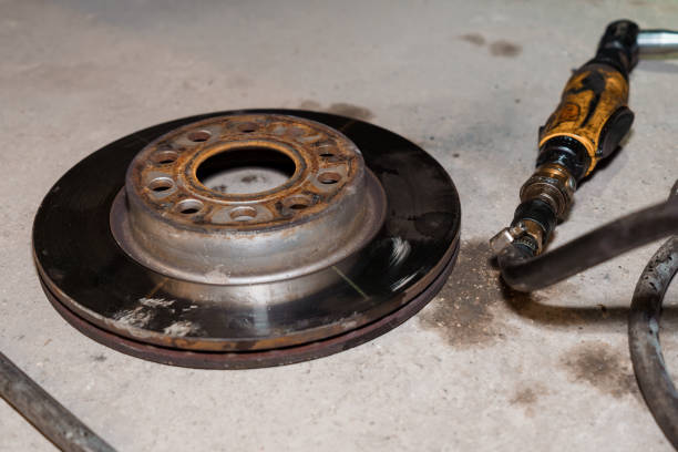 istock Rusty Brake Rotor with Air Tool on a Grimy Garage Floor 2196192709
