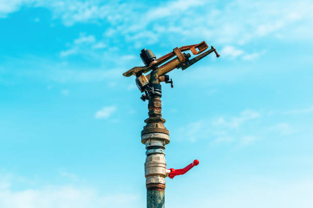 Water irrigation impact sprinkler in operation in field, selective focus