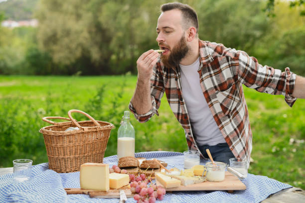 Handsome Male Trying Yellow Cheese With Closed Eyes Enjoying Every Bite