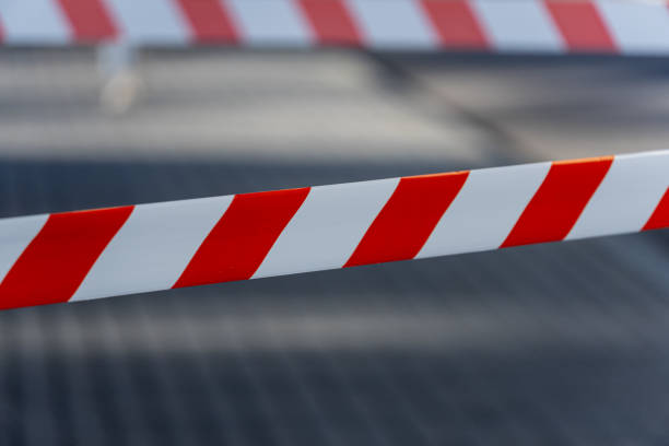 istock Bright striped caution tape warns pedestrians of danger and restricted access in a bustling city environment during daylight hours 2196199075