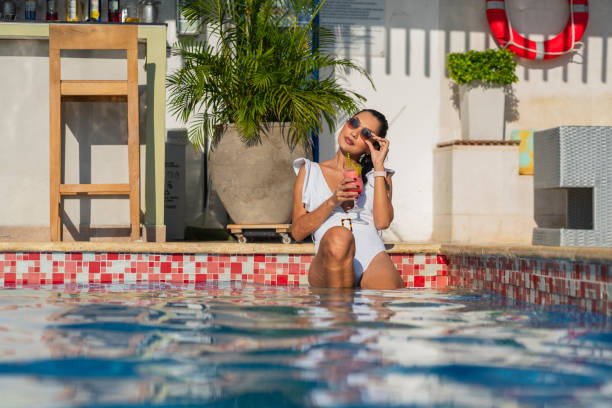 istock Woman enjoying her vacation by the pool having a cocktail 2196199329