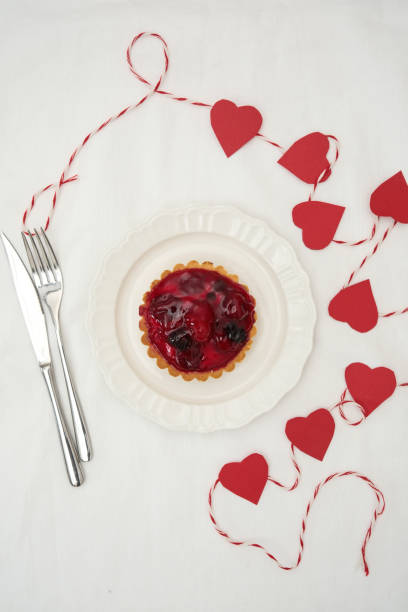 Delicious Berry Tart with Charming Romantic Heart Decorations for All Occasions on white bacground. High quality photo