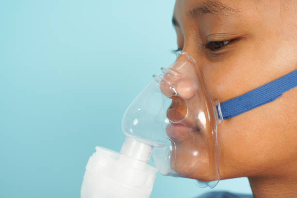 istock Young Girl Using a Nebulizer Mask for Breathing Therapy 2196201200