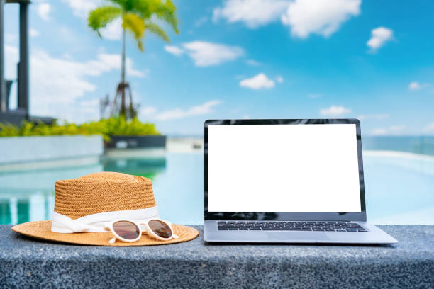 istock Empty screen laptop with travel accessories at tropical resort, Summer vacation concept 2196202630