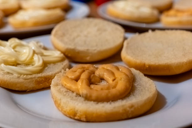 Various bread slices topped with creamy spreads, showcasing a simple food preparation activity at home stock photo