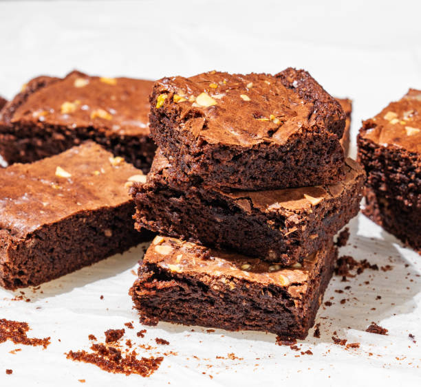istock Chocolate brownie with nuts cut into pieces on baking paper close-up with morning light. 2196204022