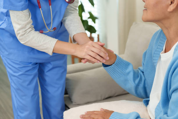 istock Close-up of nurse gently holding elderly womans hand during home care session. Emphasizes compassionate connection, trust, and emotional support for patient recovery and well-being. 2196204094