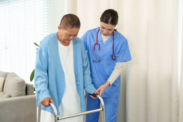 istock Nurse supporting elderly woman using walker during rehabilitation at home. Emphasizes encouragement, care, and focus on building strength and independence in recovery process. 2196204133