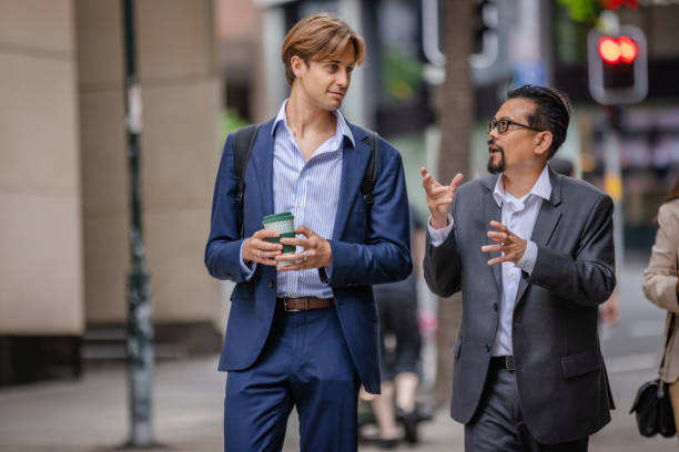 istock Busy professionals engage in conversation while walking through the streets of Sydney, Australia during the workday 2196207171