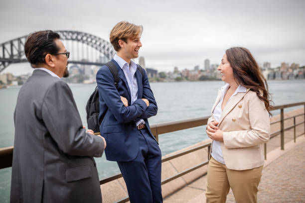 istock Professional adults engaged in conversation by Sydney Harbour with iconic bridge in the background 2196208265