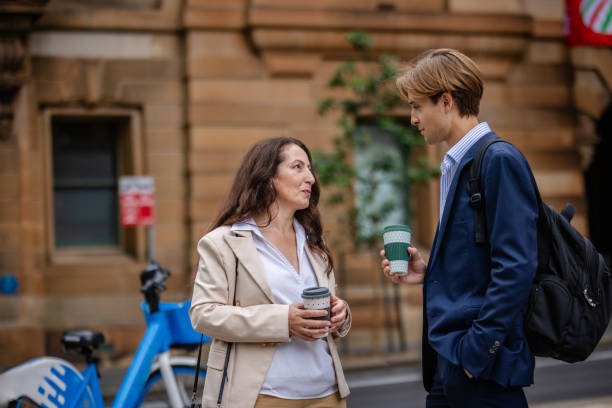 istock Professionals engaging in conversation while enjoying coffee in Sydney's bustling city streets 2196209852