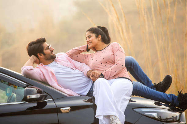 istock Loving couple looking at each other while relaxing on car 2196215209