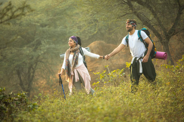 istock Young couple holding hands and hiking in forest 2196217334