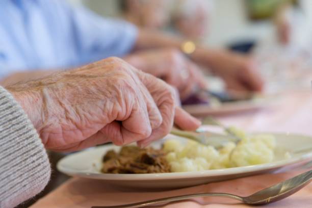 Elder people in a care home. Having dinner.