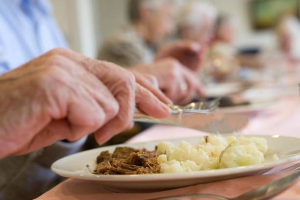 istock Elder people in a care home. Having dinner. 2196217941