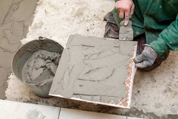 istock A man is laying tiles on a floor 2196220411