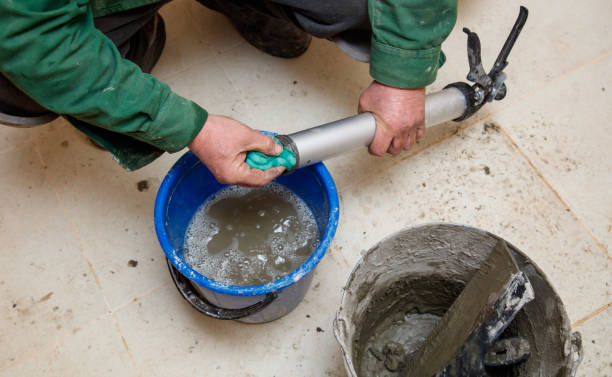 istock A man is working on a project, using a blue bucket to hold a mixture of cement 2196220555