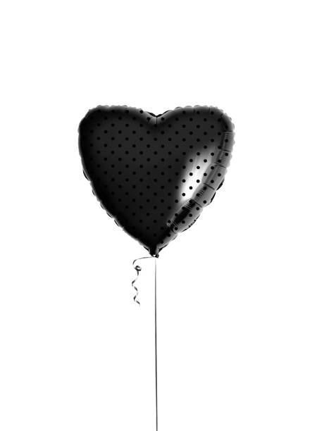 Black heart shaped balloon with dots and ribbon isolated on white background. Beautiful birthday party gift. Floating object. Inflatable ball by helium gas. Valentines day. Love symbol. Gothic party.