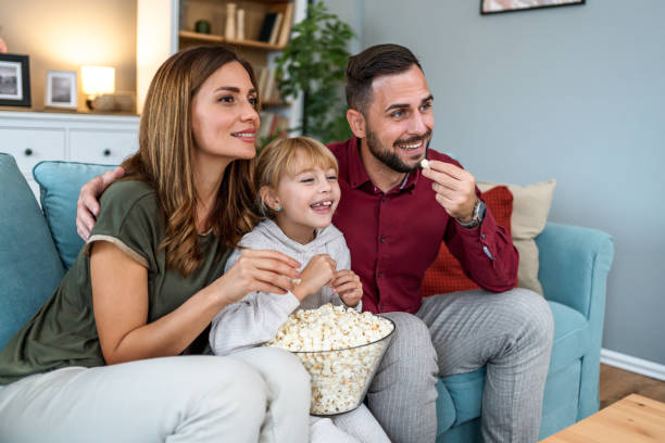 istock Parents and daughter watching a TV at home 2196223901