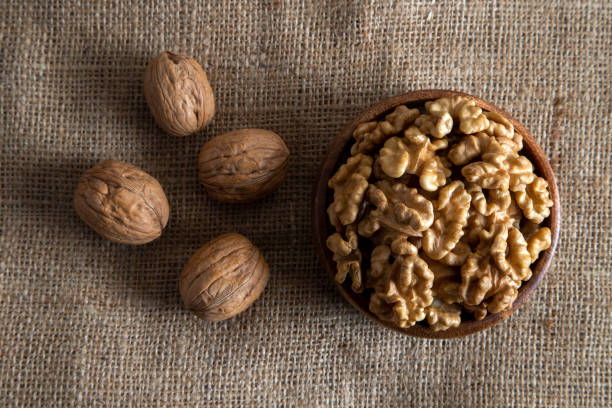 istock A bowl of peeled walnuts and a group of shells walnuts,fresh walnuts,top view 2196223921