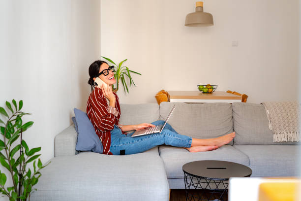 istock Woman talking on a phone while enjoying her living room 2196224032