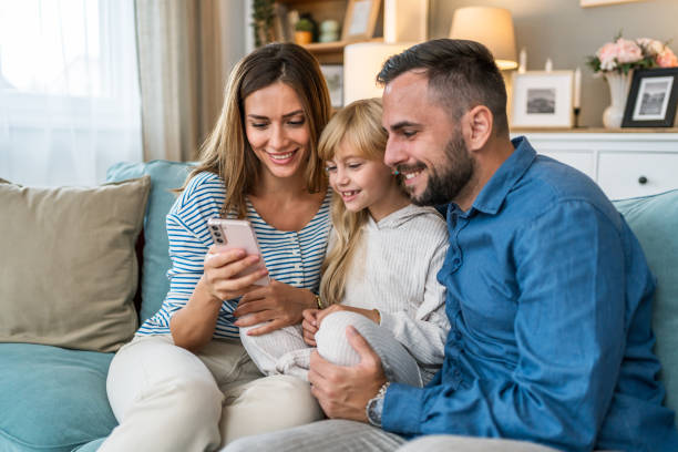 istock Parents and daughter using smartphone at home 2196226641
