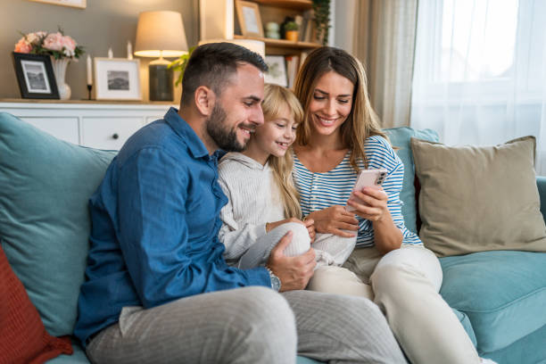 istock Parents and daughter using smartphone at home 2196226808