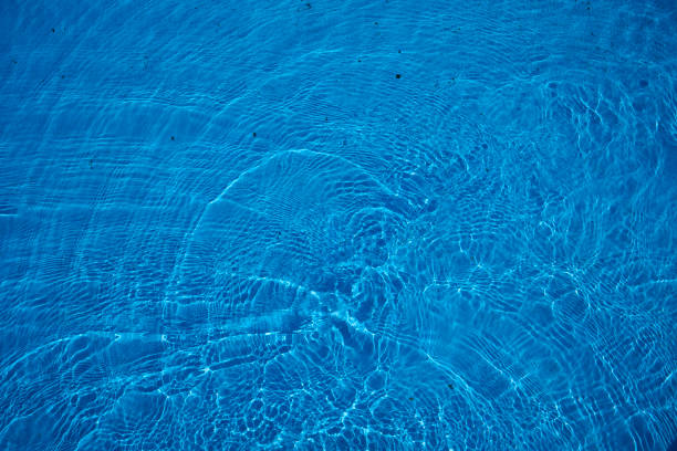 Reflecting water wave abstract surface on a sunny day and natural swirl texture, summer background. Water surface in vibrant blue. Abstract of water in swimming pool.