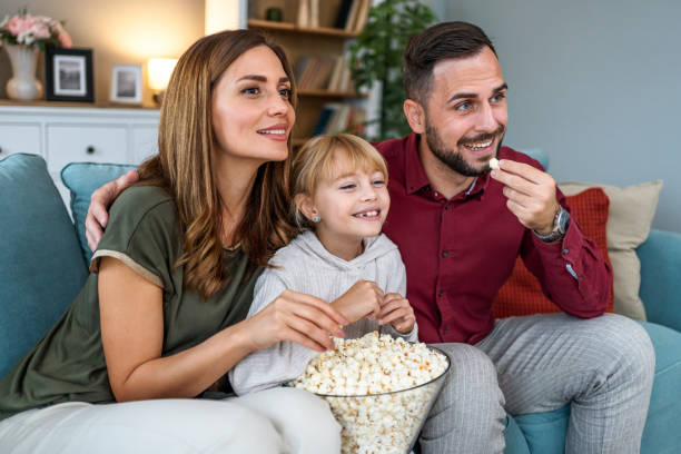 istock Parents and daughter watching a TV at home 2196227980