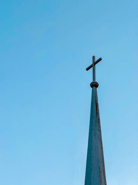 istock Church Steeple With Cross On Top Against Clear Sky 2196228341