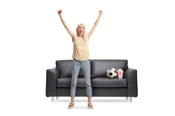istock Overjoyed young female cheering in front of a sofa 2196230003