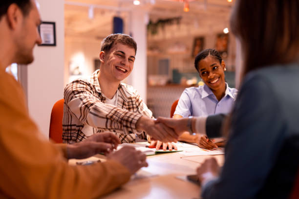 istock Young business partners shaking hands during a meeting in the office 2196235629