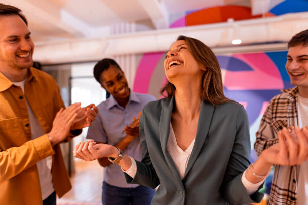 istock Businesswoman laughing and feeling appreciated by colleagues clapping 2196236018