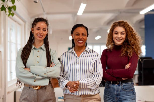 istock Confident Team of Three Women Smiling in a Bright Workspace 2196236146