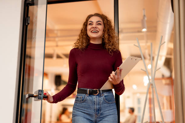 istock Smiling Woman Holding Clipboard Entering Bright Office Workspace 2196236184