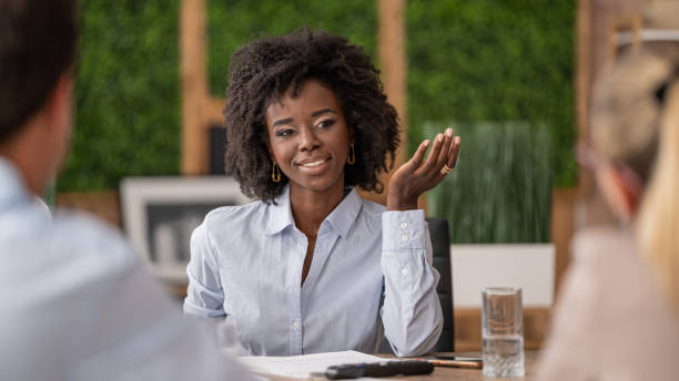 istock Confident woman presenting ideas in team setting, hand gesture conveying assurance. 2196237676