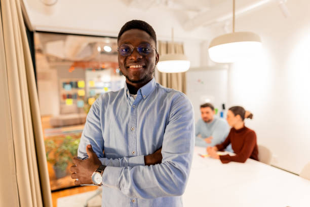 istock Confident young businessman smiling with arms crossed in modern office 2196238084