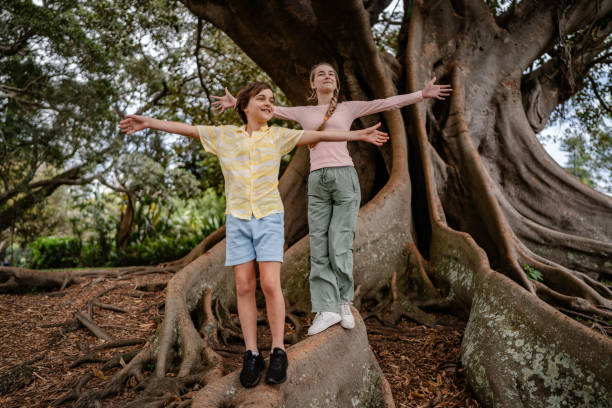 istock Children enjoying a sunny day outdoors at a tree in Sydney, Australia while embracing nature and each other 2196238090