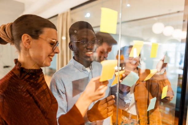 istock Business team brainstorming using sticky notes on glass wall in modern office 2196238153